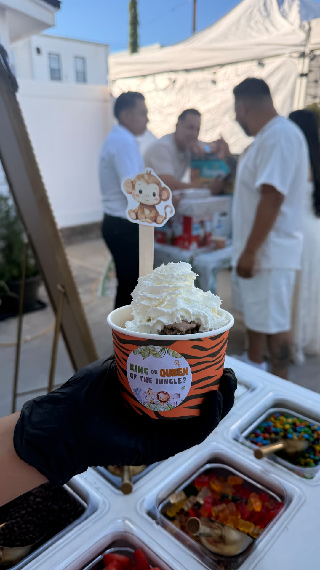 Jungle-themed ice cream sundae cup topped with whipped cream and a monkey topper
