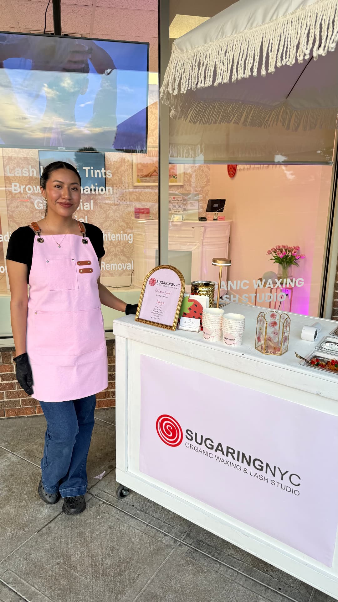 Johanna in her pink apron beside a branded dessert cart